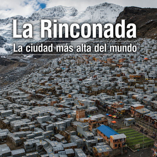 Vista aérea de La Rinconada, Perú, con casas en la ladera y montañas nevadas al fondo.
